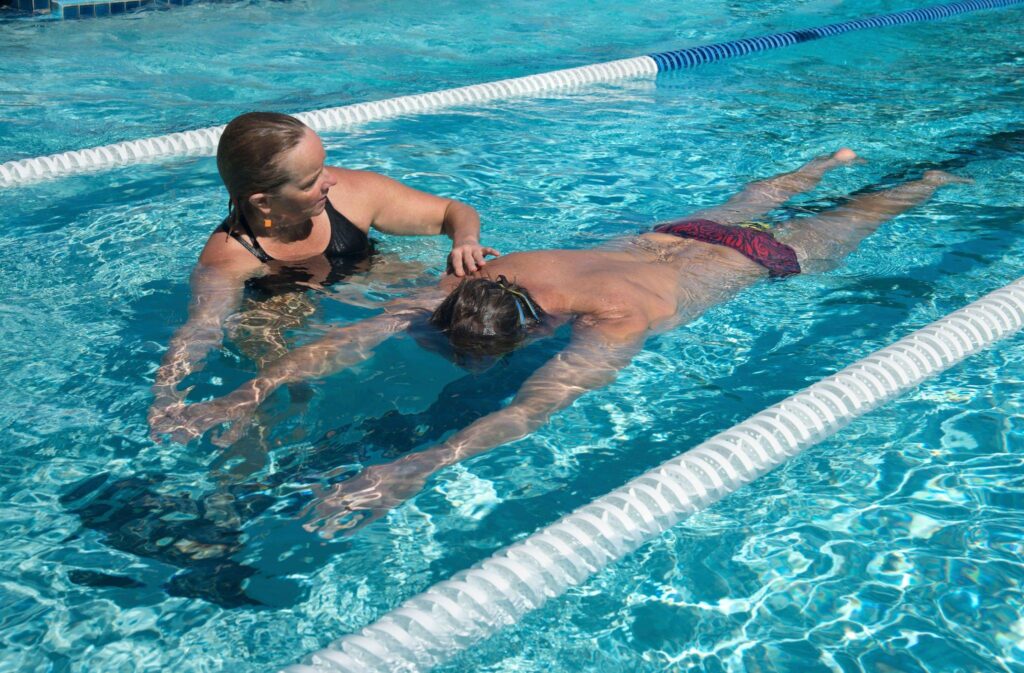 A trainee having his swim session with her private swim instructor.